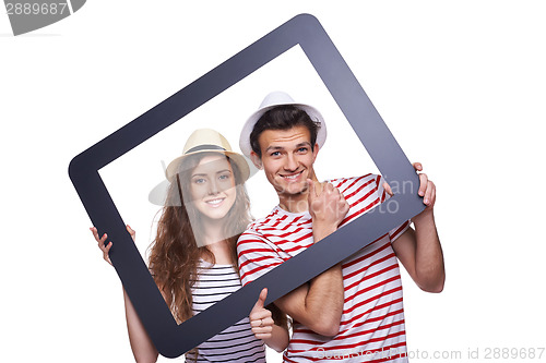 Image of Happy couple looking through tablet frame