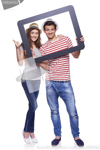 Image of Happy couple looking through tablet frame