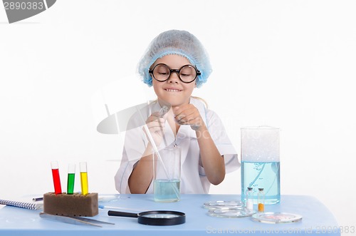 Image of Child chemist opens the flask with reagent