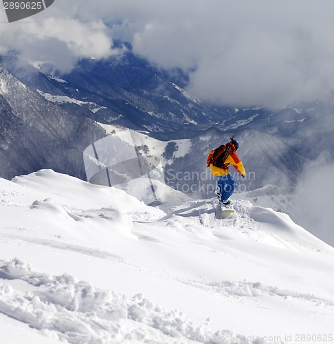 Image of Snowboarder on off-piste slope an mountains in haze