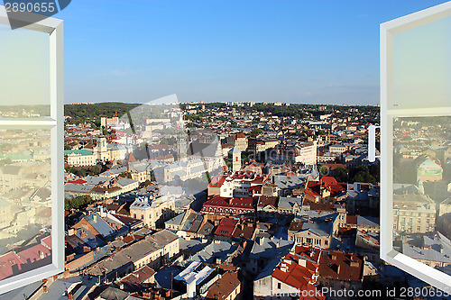 Image of opened window to the roofs of city