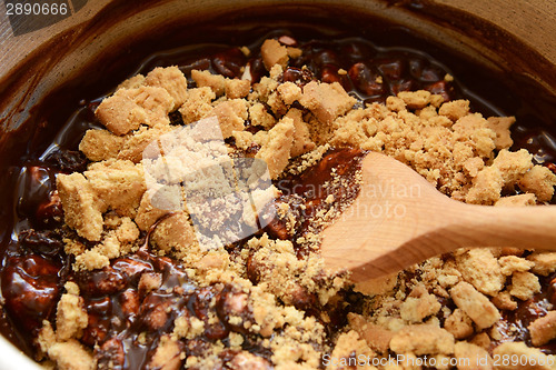 Image of Stirring crushed biscuits into melted chocolate