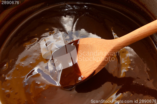 Image of Melted chocolate being stirred with a wooden spoon