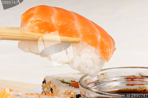 Image of Chopsticks holding a piece of nigiri sushi