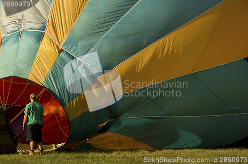 Image of Man inflating a hot-air balloon with a burner