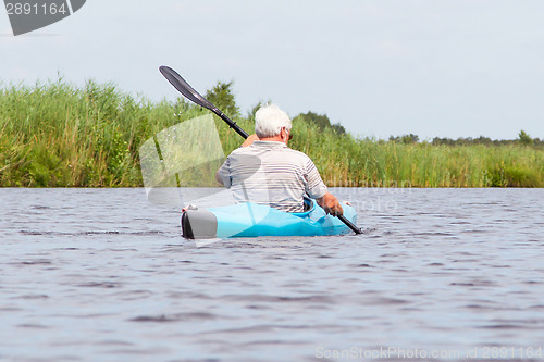 Image of Man paddling in a blue kayak