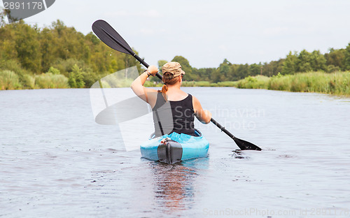 Image of Woman on a small river in rural landscape