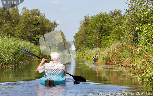 Image of Man paddling in a blue kayak