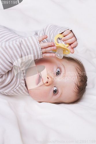 Image of Baby girl lies down on a white blanket