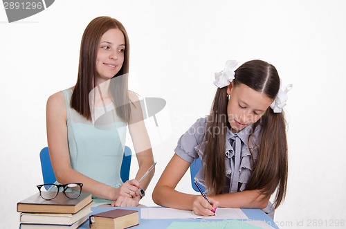 Image of Teacher looks positively on the student girl