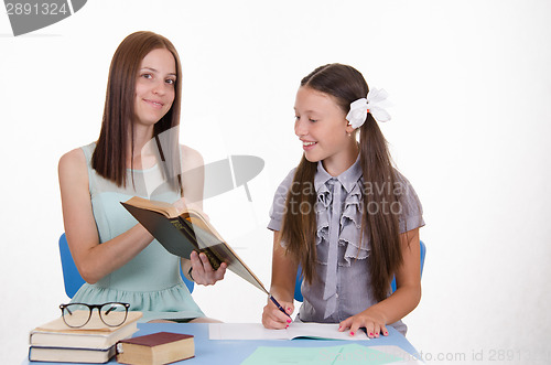 Image of Tutor shows girl job in the textbook