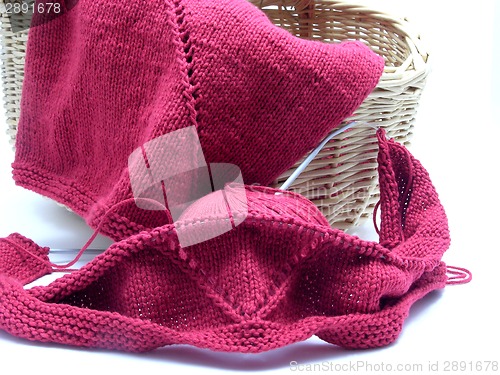 Image of Red knitting with whole pattern in a wooden basket