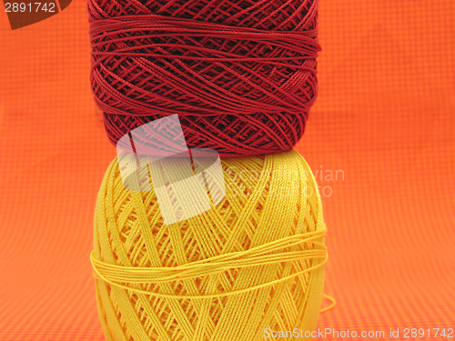 Image of Two balls of wool  on a checked background