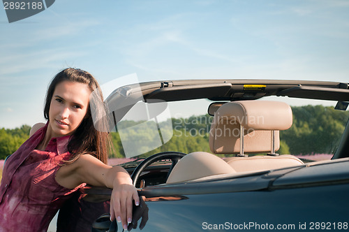 Image of Young woman recline on the car