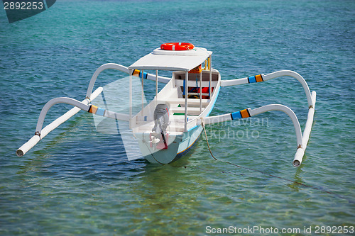 Image of Balinese traditional boat with motor - double outrigger jukung