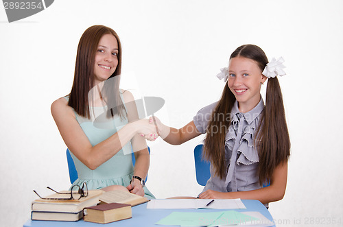 Image of Teacher and student happily shake hands with each other