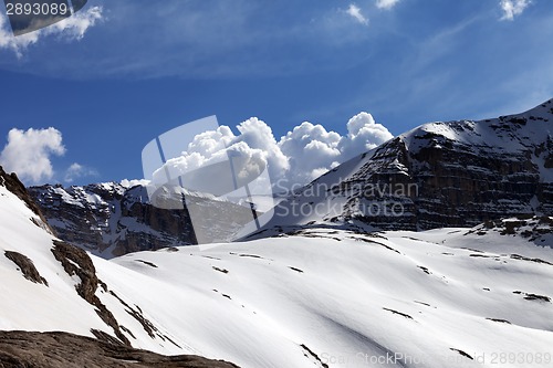 Image of Snow rocks and cloudy blue sky