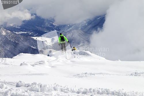Image of Freeriders on off-piste slope and mountains in mist
