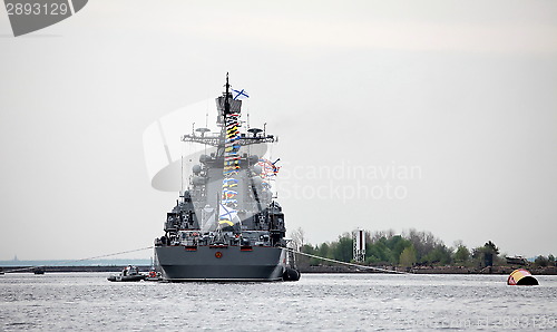 Image of warship at the pier with flags