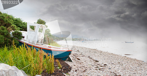 Image of Small shipwreck at a loch with stone beach