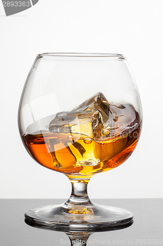 Image of Splash of whiskey with ice in glass isolated on white background