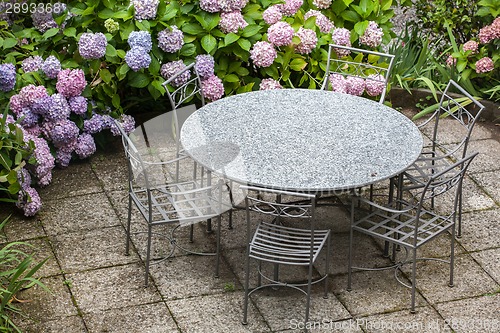 Image of table and chairs in garden with color hydrangea