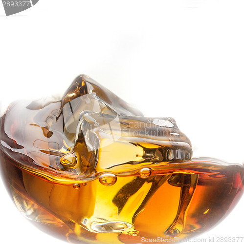 Image of Splash of whiskey with ice in glass isolated on white background