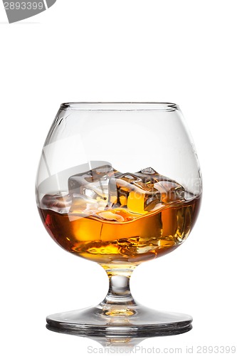 Image of Splash of whiskey with ice in glass isolated on white