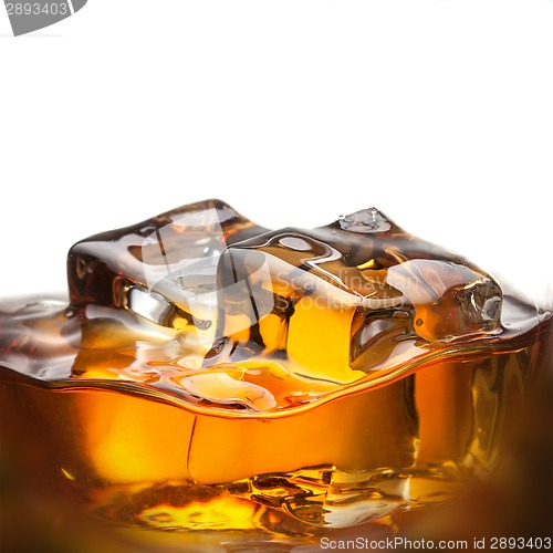 Image of Splash of whiskey with ice in glass isolated on white