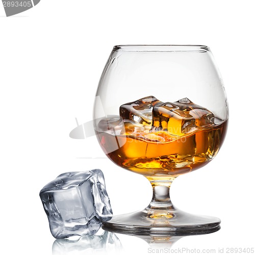 Image of Splash of whiskey with ice in glass isolated on white