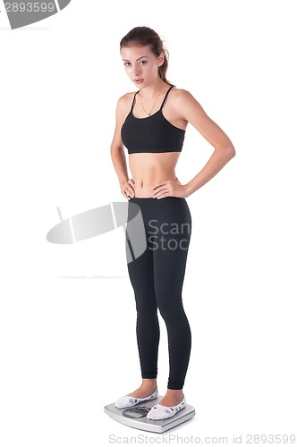 Image of Young attractive woman stands on weight scales