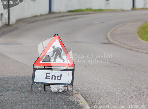 Image of Triangular construction sign standing on footpath