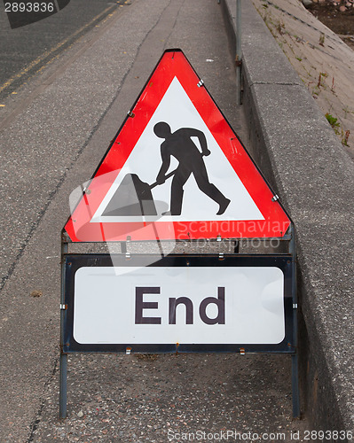 Image of Triangular construction sign standing on footpath