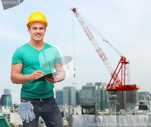 Image of smiling man in helmet with clipboard