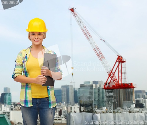 Image of smiling woman in helmet with clipboard