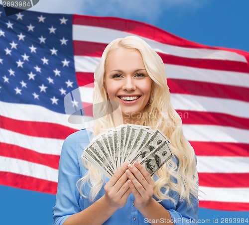 Image of smiling young woman with us dollar money