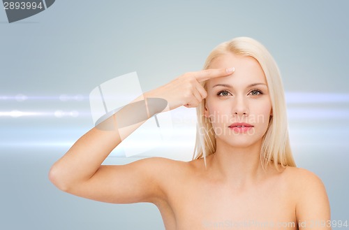 Image of beautiful woman touching her forehead