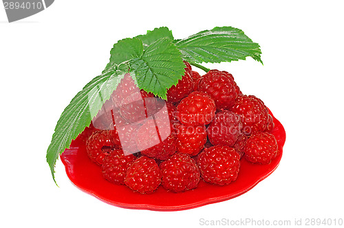 Image of Ripe raspberries decorated with green leaf in a small platter   
