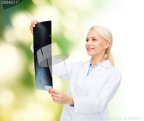 Image of smiling female doctor looking at x-ray