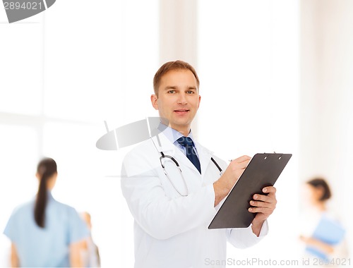 Image of smiling male doctor with clipboard and stethoscope