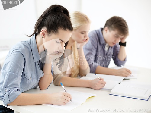 Image of tired students with notebooks at school