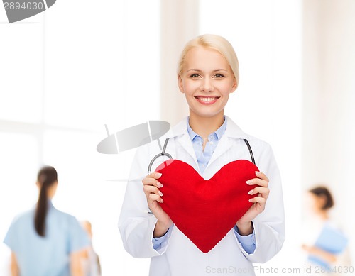 Image of smiling female doctor with heart and stethoscope