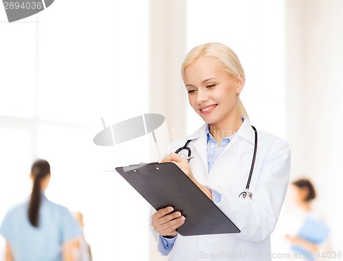 Image of smiling female doctor with clipboard