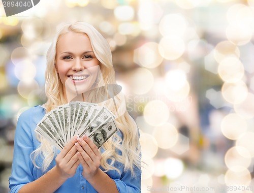 Image of smiling young woman with us dollar money