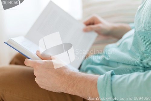 Image of close up of man reading book at home