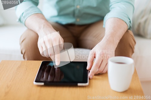 Image of close up of man with laptop and cup at home