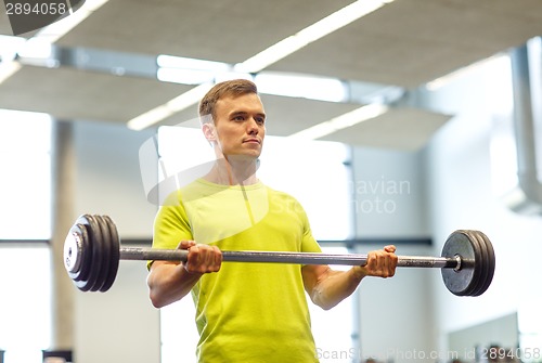 Image of man doing exercise with barbell in gym