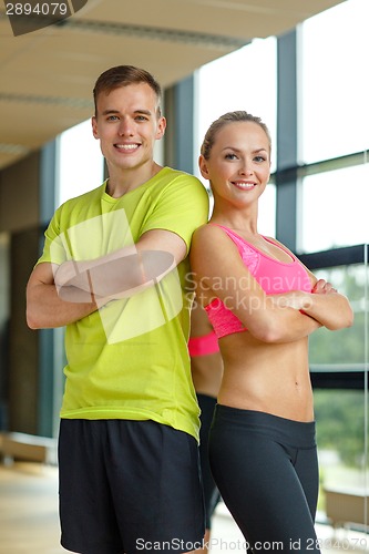 Image of smiling man and woman in gym