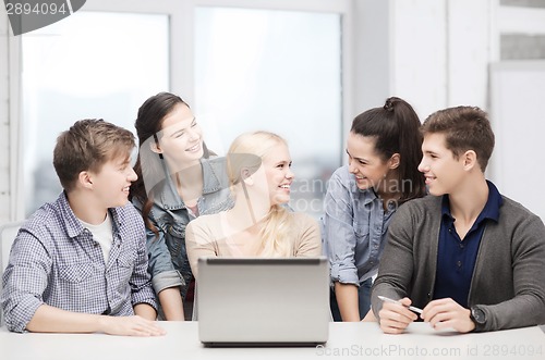 Image of smiling students with laptop at school