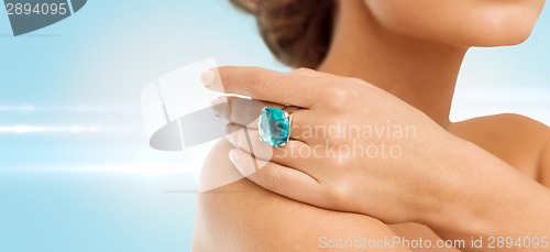 Image of closeup of woman hand with big blue cocktail ring